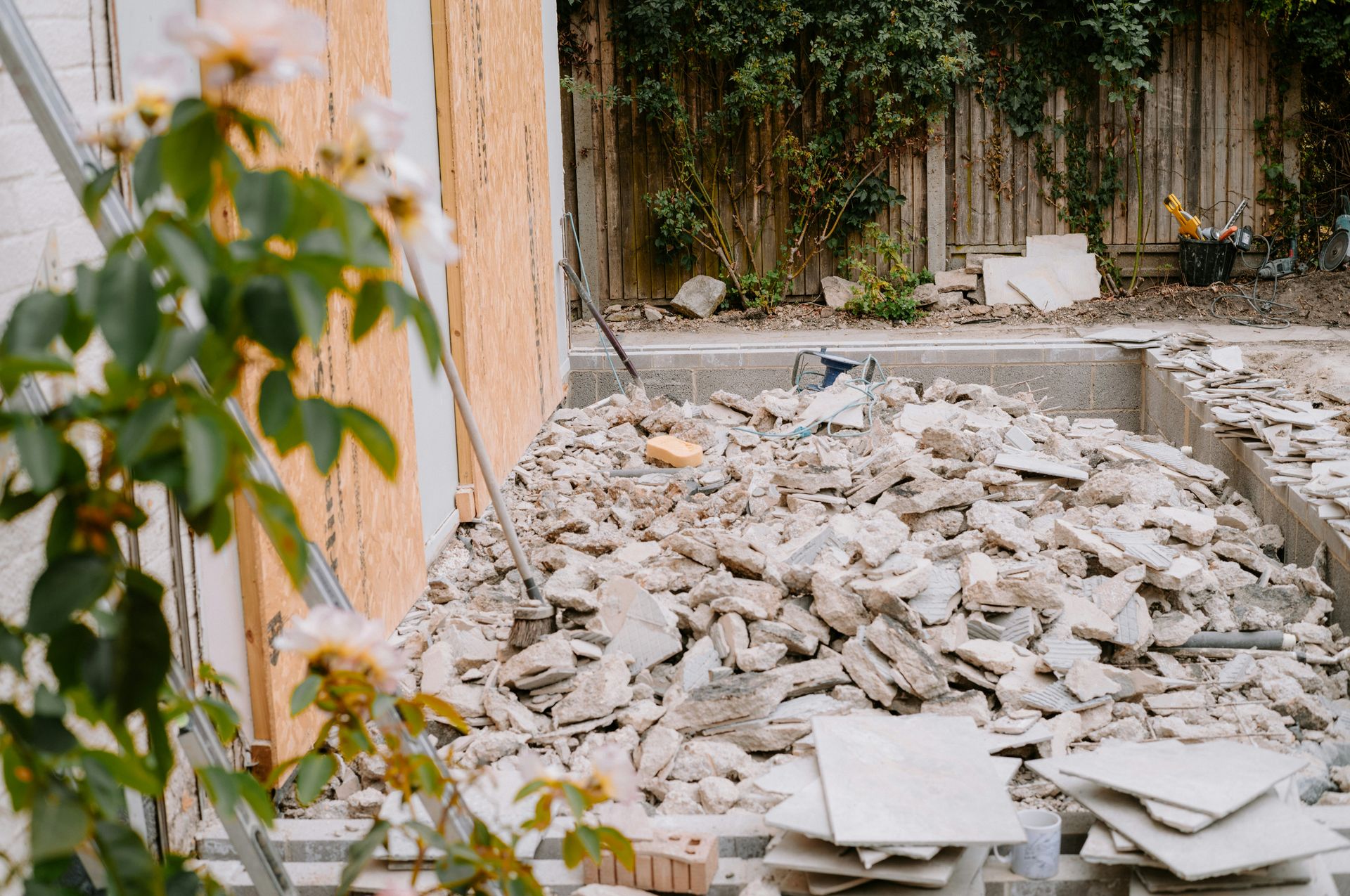 A pile of broken concrete rubble in a backyard construction site.